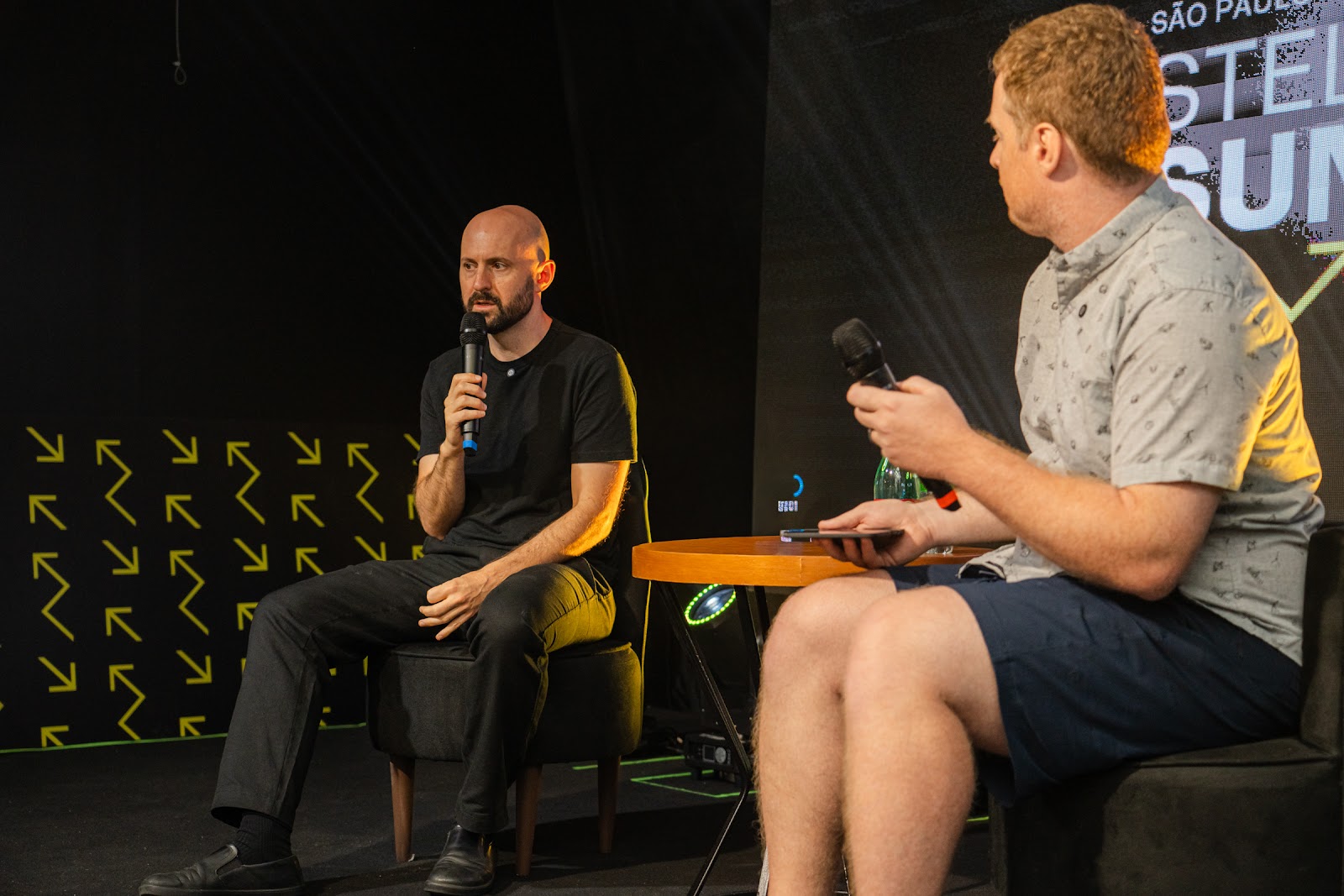 Fireside panel on the main stage, brand arrows on the backdrop