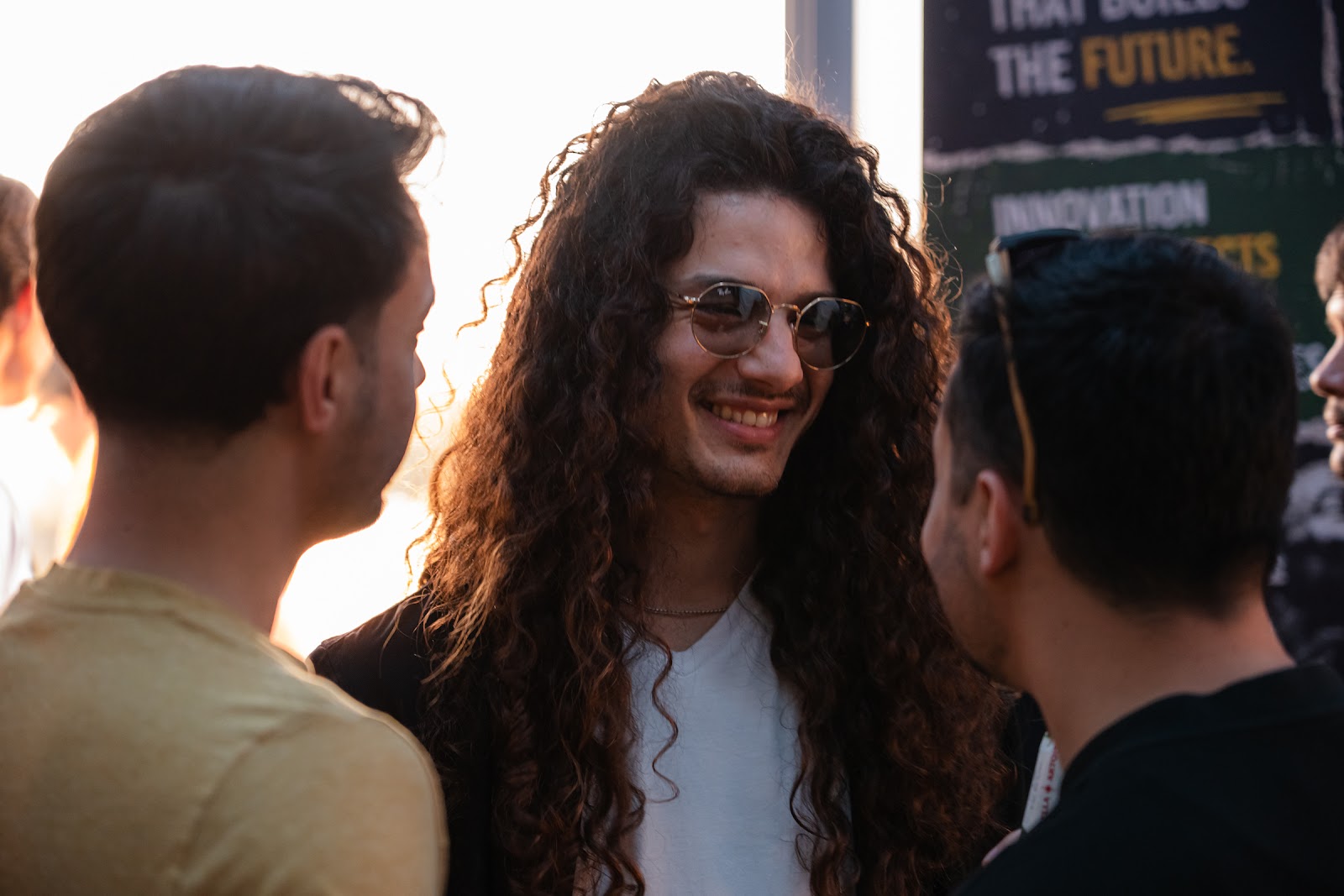 Participants talking and laughing at the golden-hour rooftop sunset